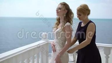伴娘蕾丝礼服新娘在露台上。海上婚礼。